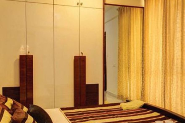 "A stylish bedroom with sleek decor and practical storage."